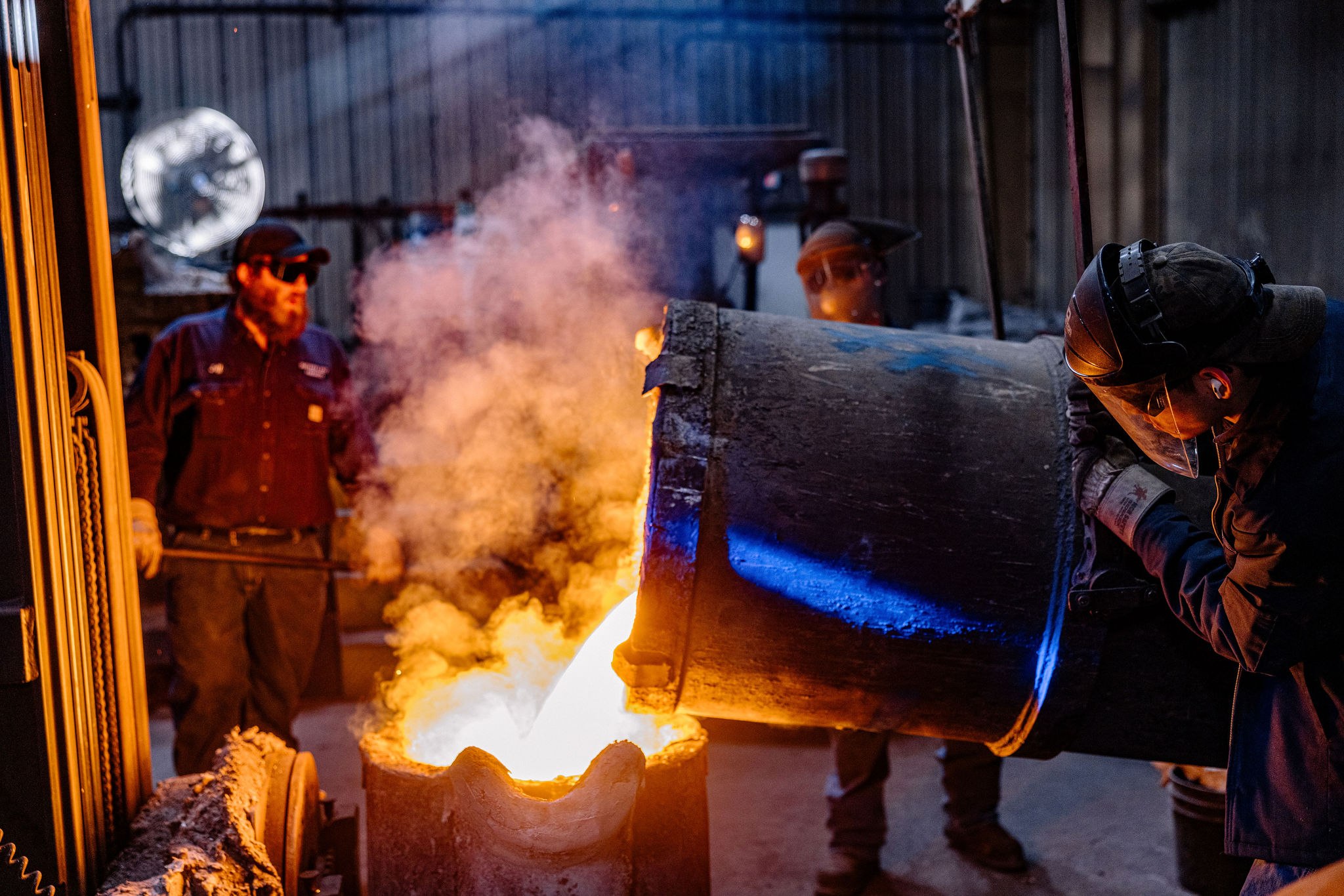 Active ladle pour on the shop floor — representative of the ductile-iron and cast carbon-steel heats that feed municipal water and wastewater body work at the 1 to 100 piece scale.