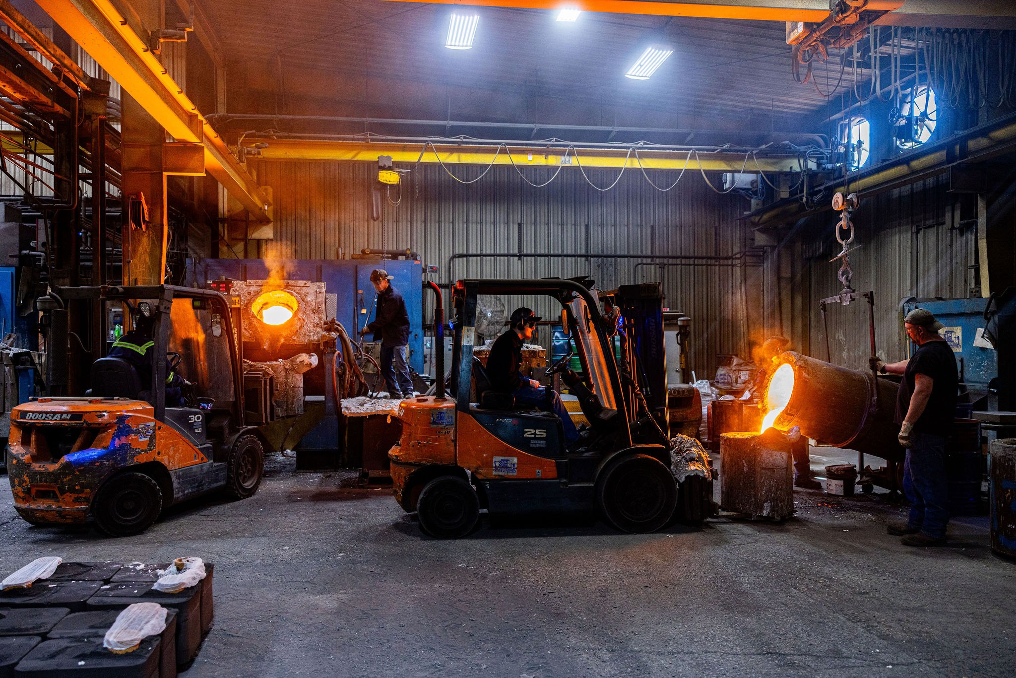 Molten metal pour on the foundry floor — patternless short-run replacement casting mid-pour into a 3D-printed sand mold.